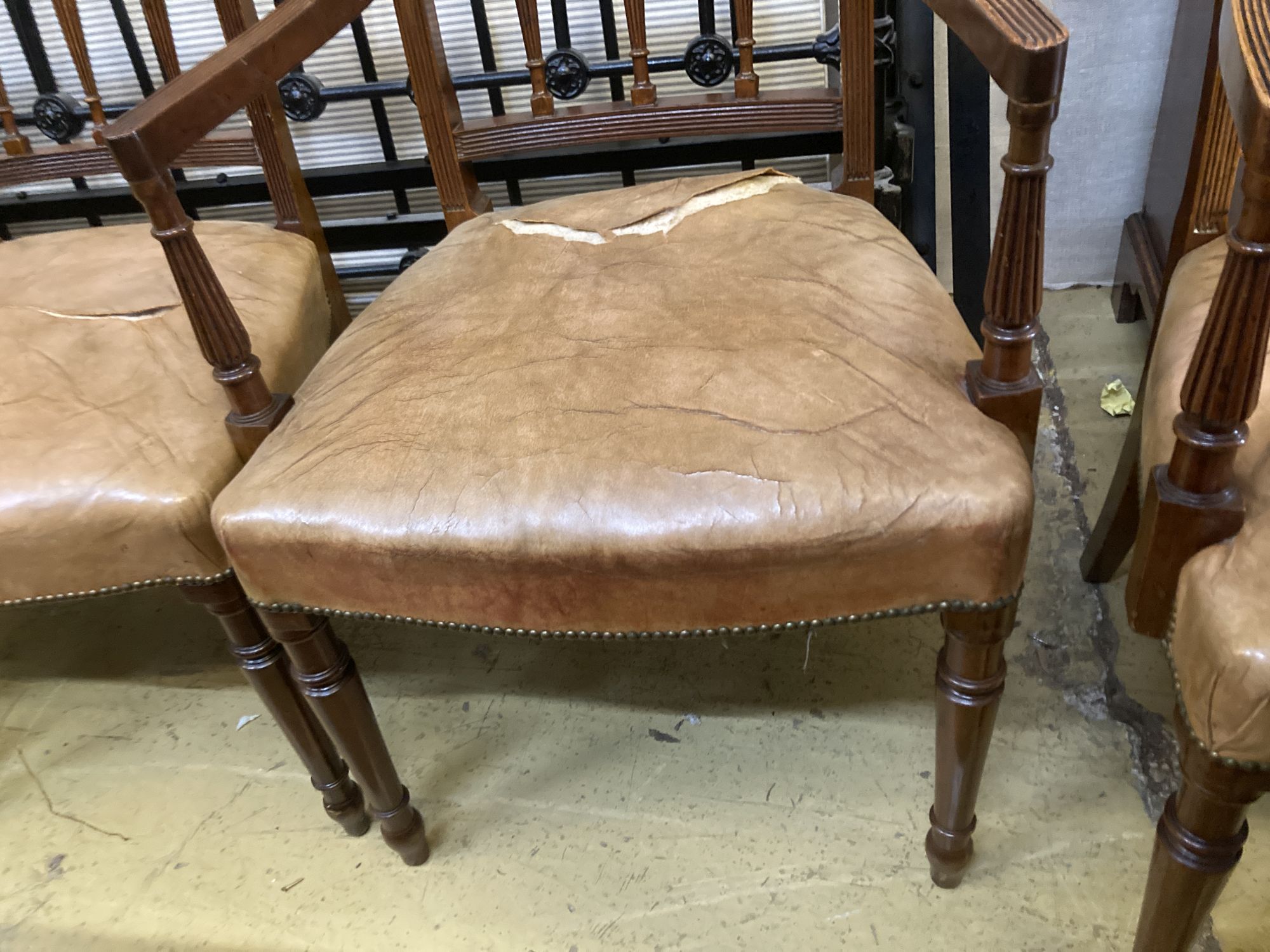 A set of eight George III style Sheraton design mahogany dining chairs, with leather stuff-over seats